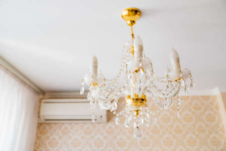 Beautiful classic crystal ceiling lamp on the ceiling of the apartment.の写真素材