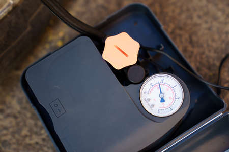 compressor with built-in pressure gauge. inflates a flat car wheel. tire service