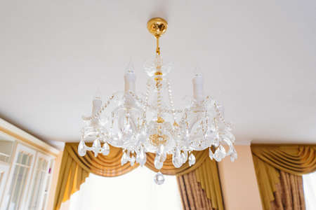 Beautiful classic crystal ceiling lamp on the ceiling of the apartment.の写真素材