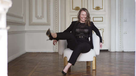 a funny and attractive woman in a black suit is having fun.