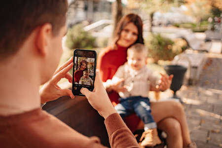 beautiful and happy family photographed on the bench of the autumn embankment.の写真素材