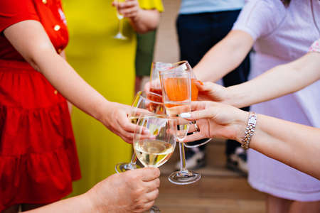a womans hands with glasses of white wine.の写真素材