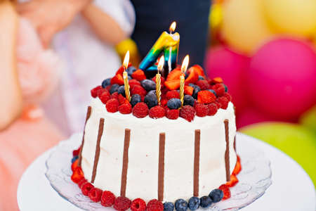 traditional cake for a childrens birthday party with a candle number four.の写真素材