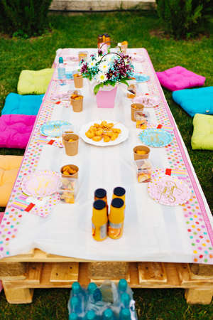 setting a table for a childrens holiday in the courtyard of a house on the lawnの写真素材