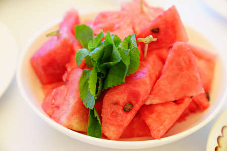pieces of watermelon and mint on a plate.の写真素材