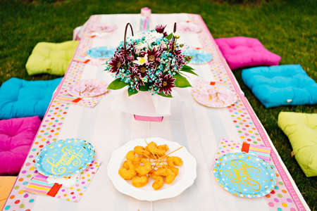 setting a table for a childrens holiday in the courtyard of a house on the lawnの写真素材