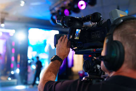 videographer with broadcast video camera to show on large screens.