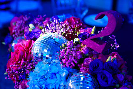 decorated in disco style table in a dark banquet hall.