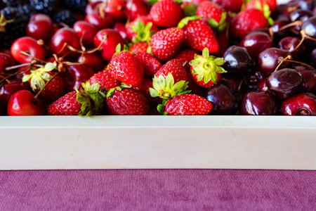 tray with strawberries, cherries and blackberries on a tray.