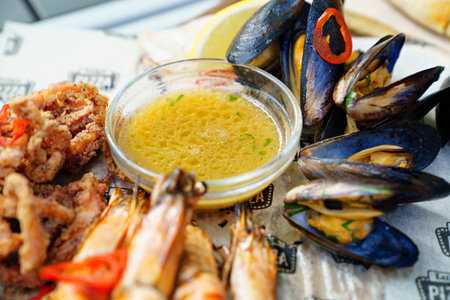 seafood. mussel, squid and shrimp cooked on the grill with sauce and vegetables.のeditorial素材