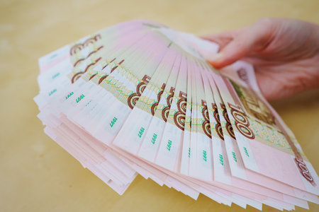 a woman holds in her hands a fan of Russian banknotes of 100 rubles.