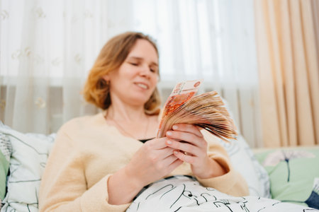 selective focus. a women count a money of a banknotes of 5000 rubles in bed