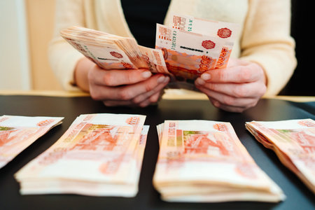 womens hands count a stack of money of a banknotes of 5000 rubles on a black