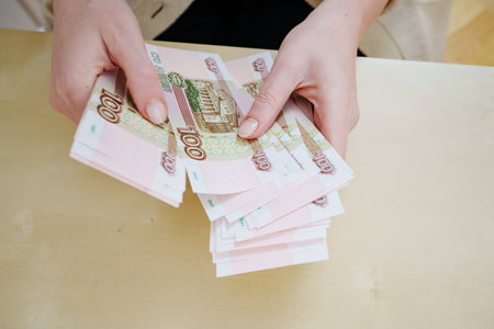 a woman holds in her hands and recalculates Russian banknotes of 100 rubles.の写真素材