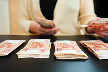 womens hands count a stack of money of a banknotes of 5000 rubles on a black