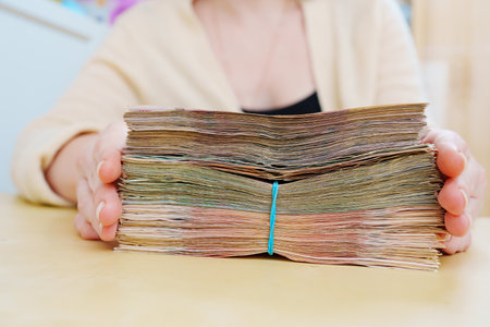 womens hands hold a stack of rubles tied with a rubber band.の写真素材