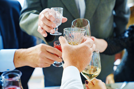 hands with glasses of alcoholic beverages over festiv table. photo without face