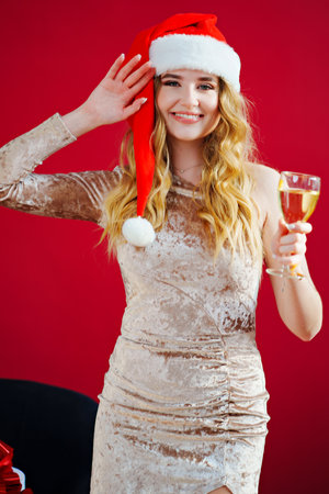 woman in santa hat with champagne and sparklers in red roomの写真素材