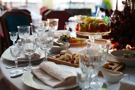 table setting for a festive dinner. empty wine glasses, tableware and snacks.の写真素材