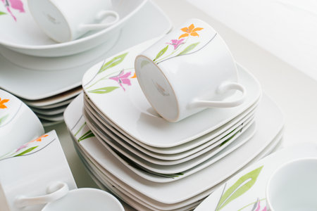 cups and plates with the image of flowers on a white table