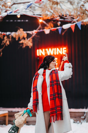 an attractive brunette woman with champagne and a bouquet of spruce branches.の写真素材