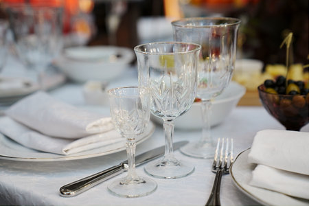 table setting for a festive dinner. empty wine glasses, tableware and snacks.の写真素材