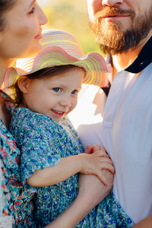close-up. a mom and a dad with a baby daughter in a blooming spring garden.の写真素材