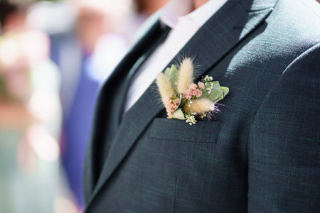 a dried flower boutonniere in the pocket of a mans jacket.
