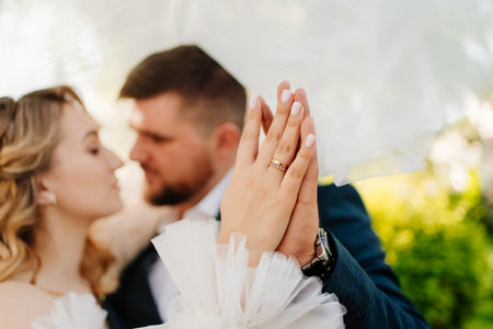 the bride and groom hold hands with wedding rings. Selective focus.の写真素材
