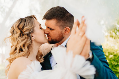 the bride and groom hold hands with wedding rings and kiss. Selective focus.の写真素材