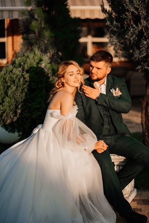 the gentle bride and groom on a park bench.の写真素材