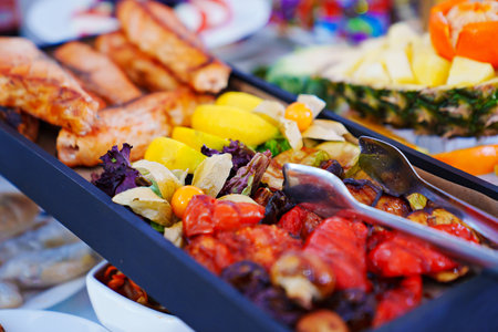 rectangular black dish with grilled fish and vegetables.の写真素材