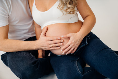 a mans hand on the stomach of a pregnant woman.の写真素材