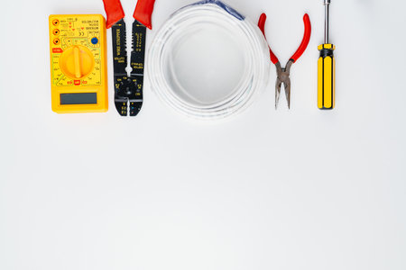 Stripper, Pliers, Multimeter, Wire and Screwdriver on a white background