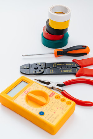 Stripper, Pliers, Multimeter, insulating tape and Screwdriver on a white.