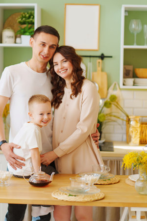 a loving family. pregnant mom, son and dad In the kitchen. a cozy houseの写真素材