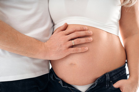 a mans hand on the stomach of a pregnant woman.の写真素材