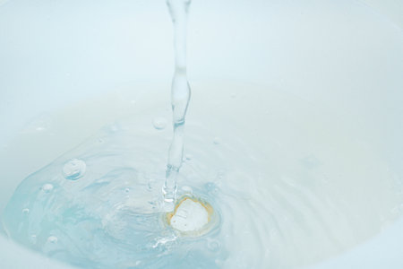a jet of water pours into a container of water.の写真素材