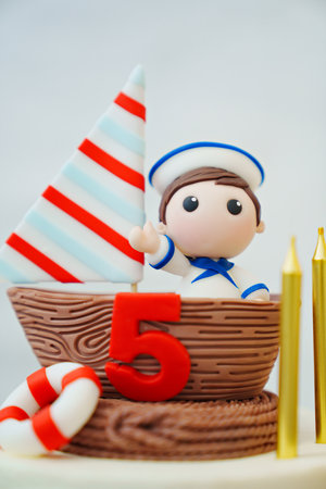part of cake in the marine style decorated with a sailboat with a sailor.の写真素材