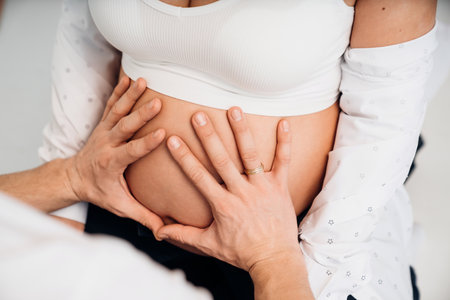 a mans hand on the stomach of a pregnant woman.の写真素材