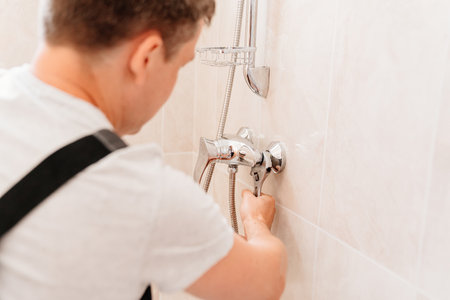 A plumber repairs or installs a faucet faucet in the bathroomの写真素材
