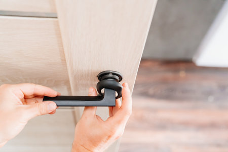 The master repairs or installs the door handle on the interior door.の写真素材