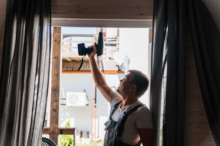 A silhouette of repairman repairs window frames or glass doors on the terrace.の写真素材