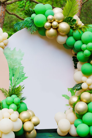 Photo zone in the park at a birthday party - green balloons form an archの写真素材