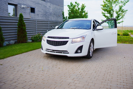 Clean white car in the parking lot in the courtyard of the house.の写真素材