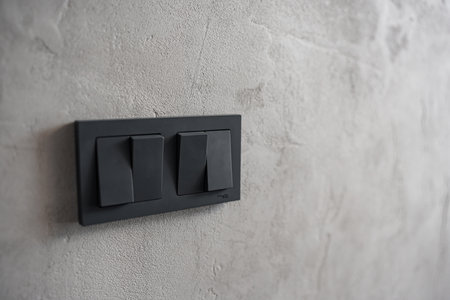 black light switch keys on a gray wall.の写真素材