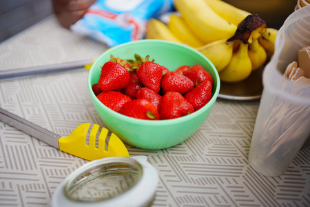 bowl with strawberries and bananas on the table for making ice cream roll.の写真素材