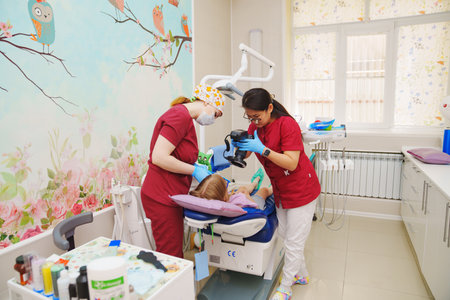 The pediatric dentist takes photos of the teeth before or after treatment.のeditorial素材