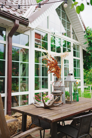 Wooden dining table with retro dishes and deer antler in the courtyardの写真素材