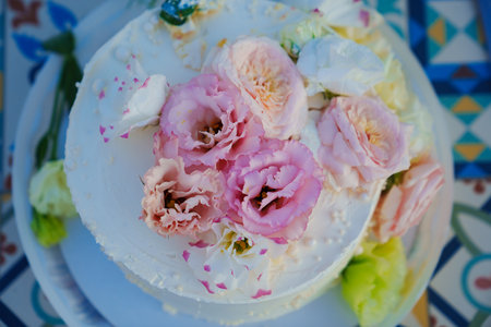Classic white cake decorated with pink and white fresh flowers.
